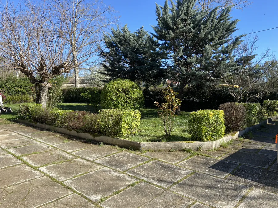 Jardin arboré et massifs entretenus près d'une terrasse