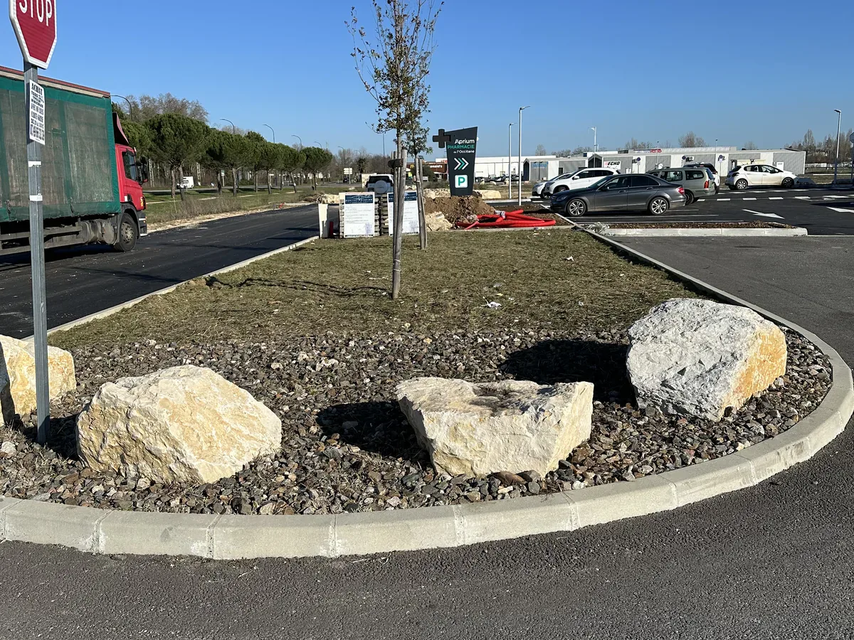 Îlot paysager après l’entretien avec les rochers et le paillage minéral dégagés