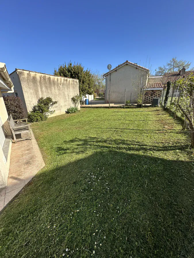 Pelouse fraîchement tondue dans le jardin arrière d’une maison