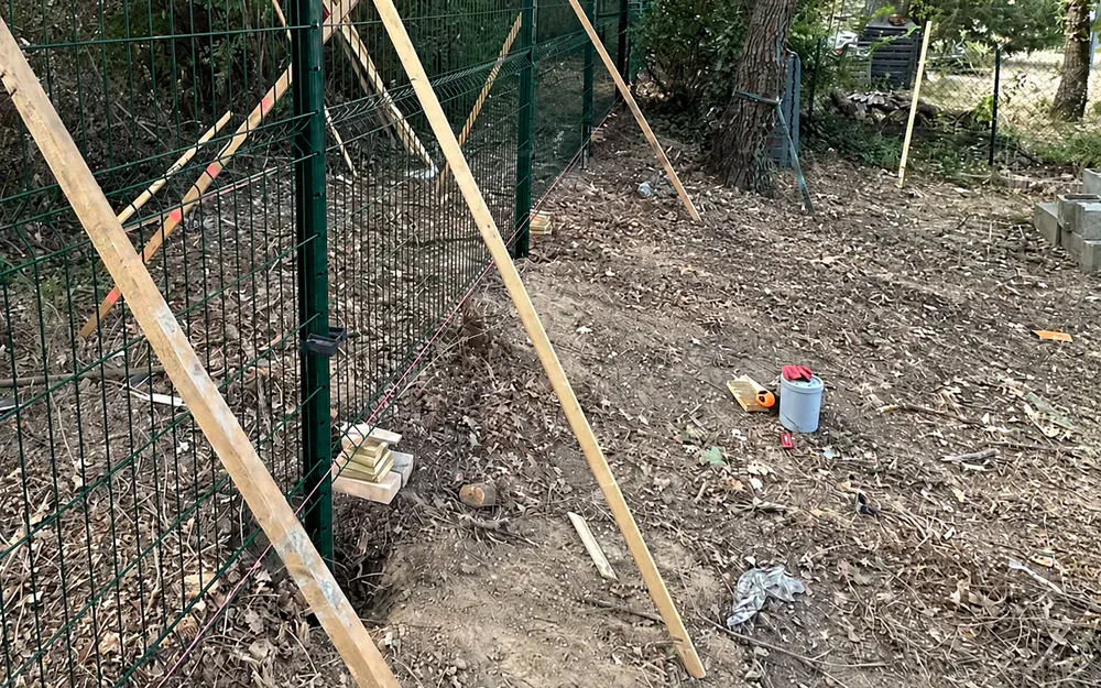 Clôture rigide maintenue par des litaux pendant la pose